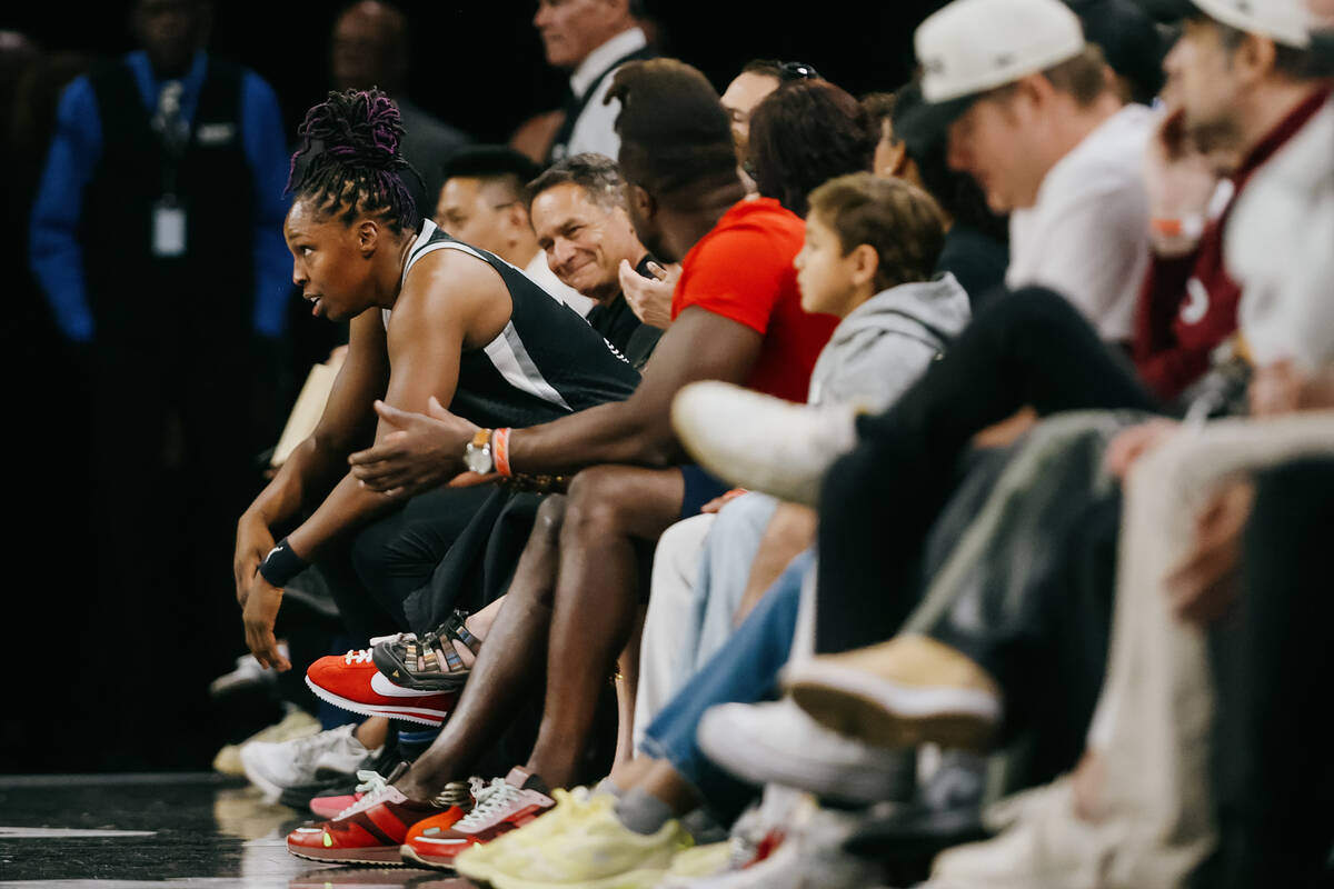 Aces guard Chelsea Gray (12) takes a seat with fans for a moment during a WNBA game between the ...