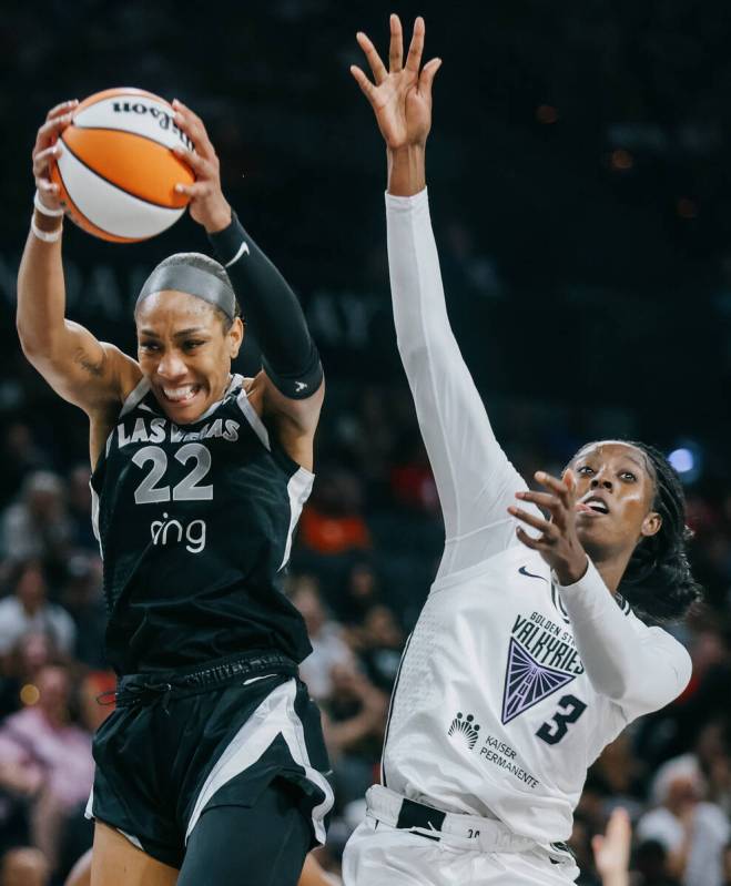 Aces center A'ja Wilson (22) reaches for the ball as Golden State Valkyries forward Laeticia Am ...