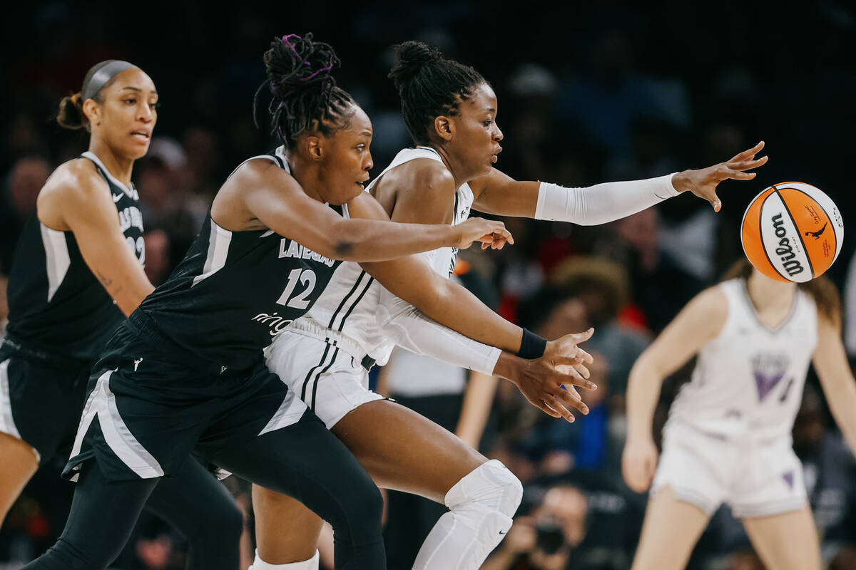 Aces center A'ja Wilson (22) and Golden State Valkyries center Temi Fagbenle (14) chase after t ...