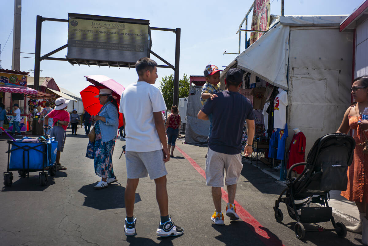 People explore the Broadacres Marketplace swap meet as a digital billboard from the Legal Aid C ...