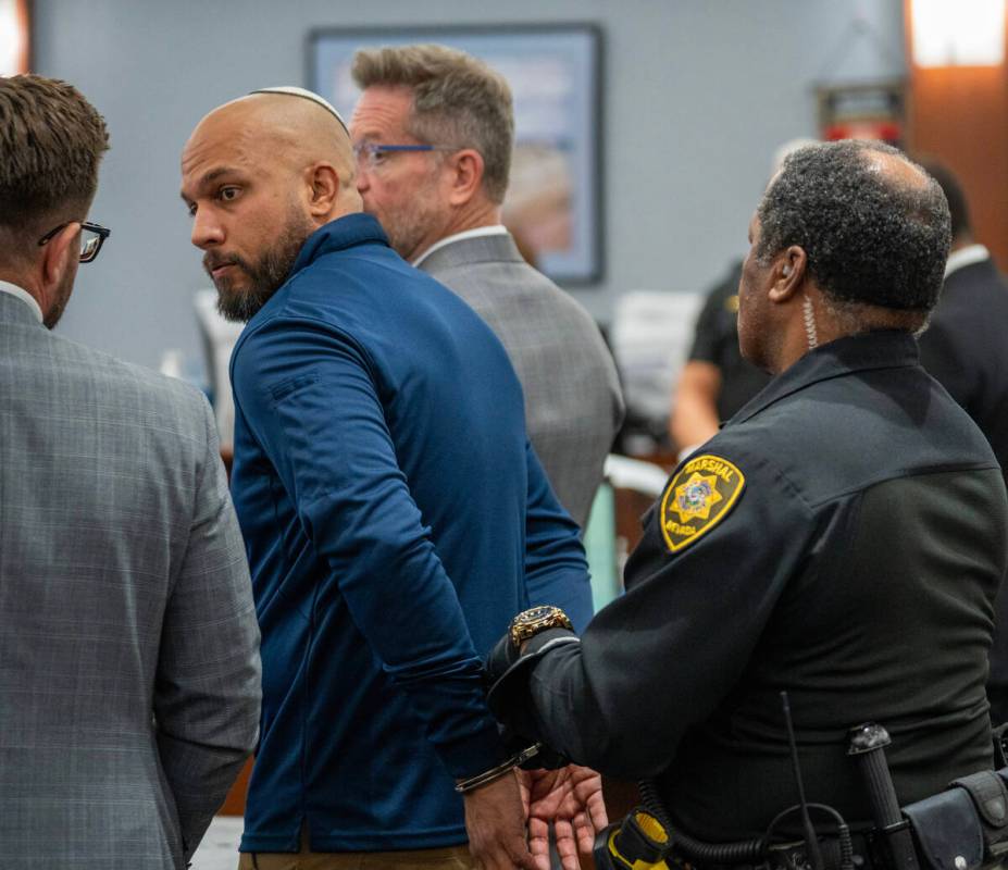 Kevin Menon, a former Metropolitan Police Department sergeant, is taken into custody during a s ...