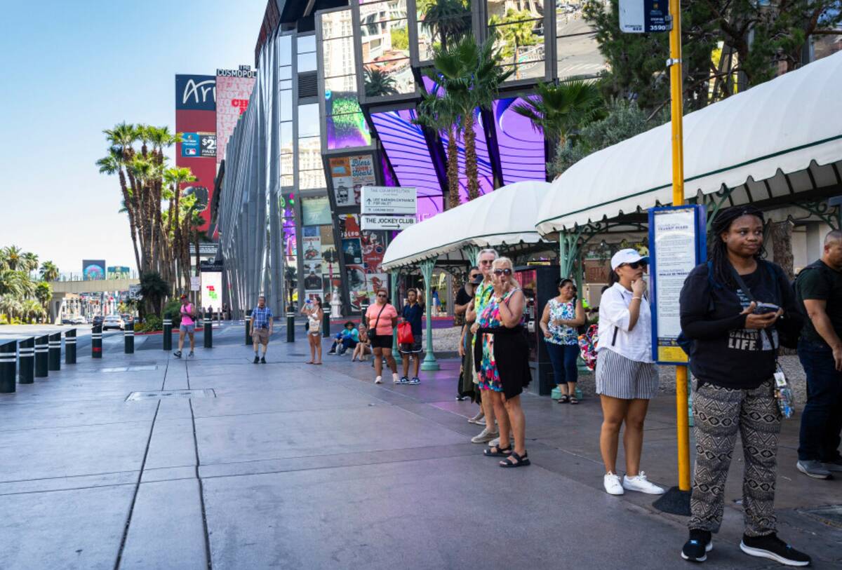 People wait at a Regional Transportation Commission bus stop between the Bellagio and The Cosmo ...