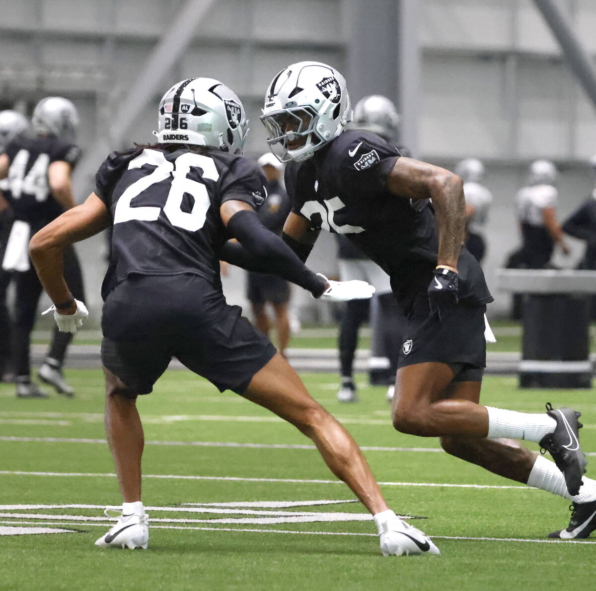 Raiders cornerback Darien Porter (26) defends Raiders cornerback Decamerion Richardson (25) dur ...