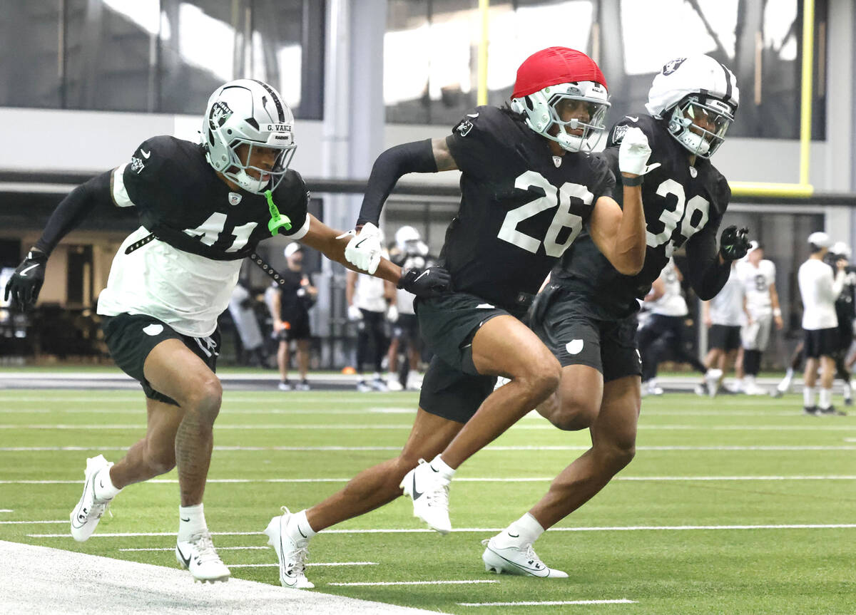Raiders cornerbacks Greedy Vance Jr. (41) and John Humphrey (39) chase cornerback Darien Porter ...