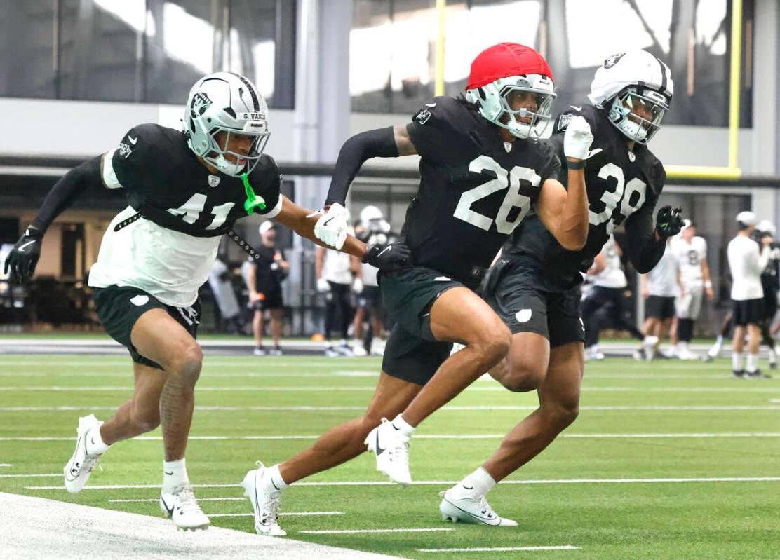 Raiders cornerbacks Greedy Vance Jr. (41) and John Humphrey (39) chase cornerback Darien Porter ...