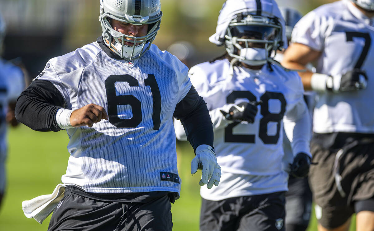 Raiders guard Jordan Meredith (61) and running back Sincere McCormick (28) warm up with teammat ...