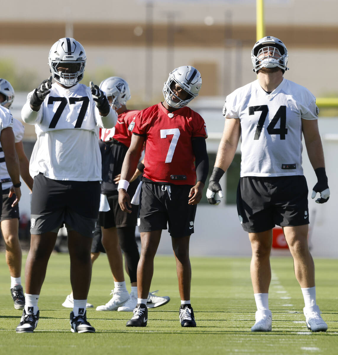 Raiders offensive tackles Thayer Munford Jr. (77) and Kolton Miller (74) stretch with quarterba ...