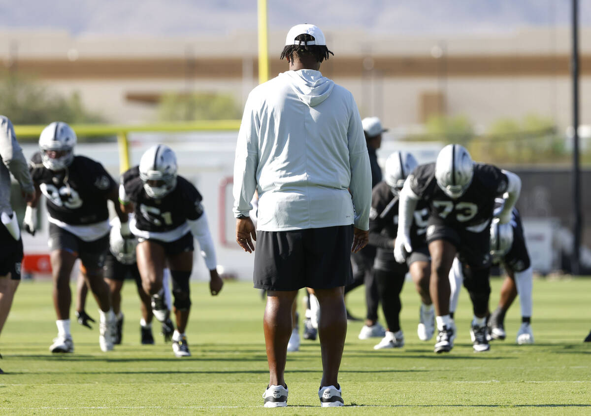 Raiders defensive coordinator Patrick Graham, center, watches as players warm up during the tea ...