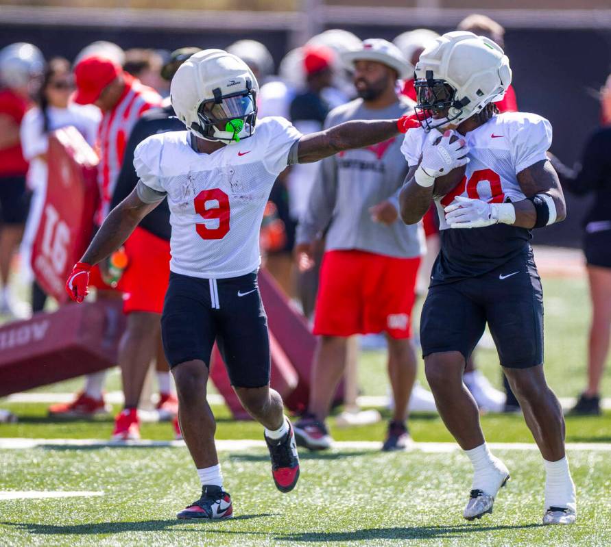UNLV running back Jai'Den Thomas (9) works a team drill with running back Jaylon Glover (20) du ...
