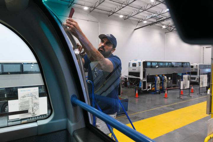 Steven Bamboyani touches up the exterior of a bus at Alexander Dennis, the nation’s only manu ...