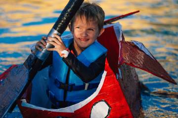 Maverick Duensing, 6, makes it to the finish line in his boat during a boat regatta competition ...