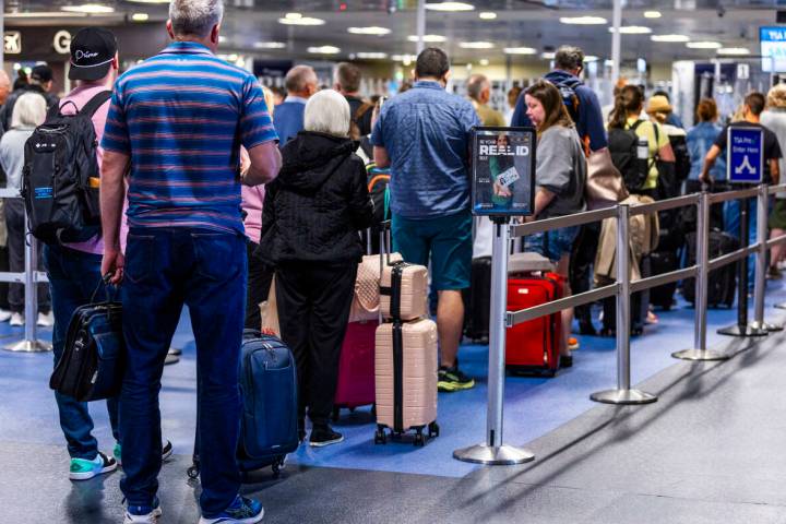 Travelers make their way to a TSA security checkpoint in Terminal One as the Real ID act is bei ...