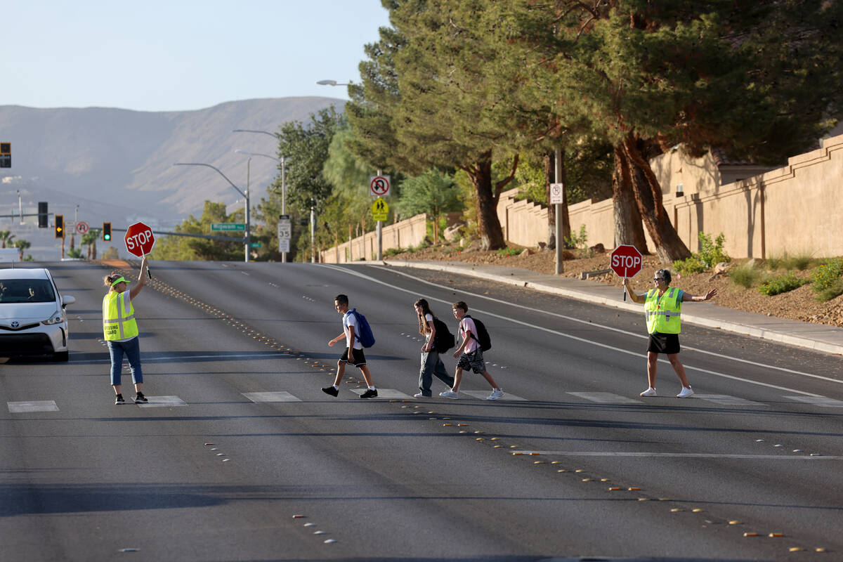 Crossing guards Sonja Castleman, left, and Cindy Branby help students get across the street on ...