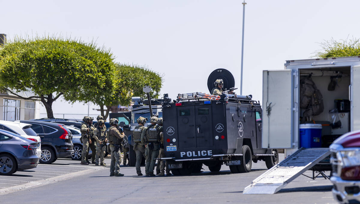 SWAT officers take cover behind their vehicles as they join North Las Vegas Police with their P ...