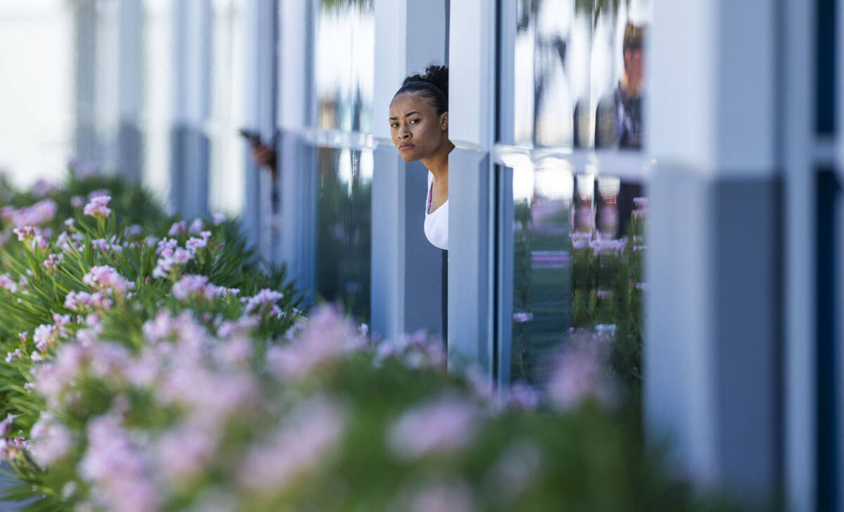 A business neighbor looks out from her door as North Las Vegas Police with their Public Safety ...