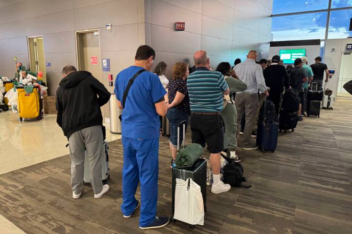 Passengers seeks updates on their delayed flight at Louis Armstrong New Orleans International A ...