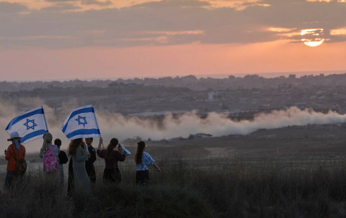 Israeli right-wing activists watch the northern Gaza Strip during a rally calling for the re-es ...