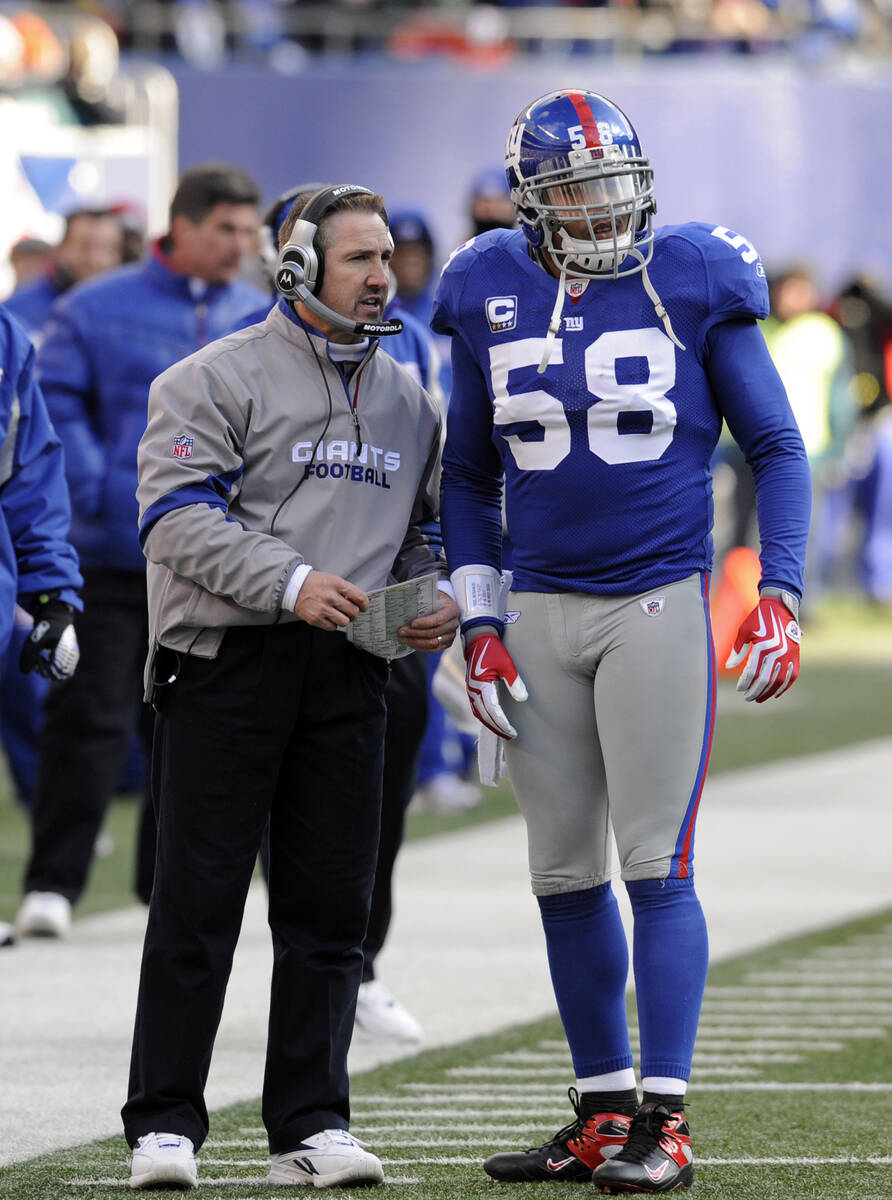 New York Giants defensive coordinator Steve Spagnuolo talks with linebacker Antonio Pierce (58) ...