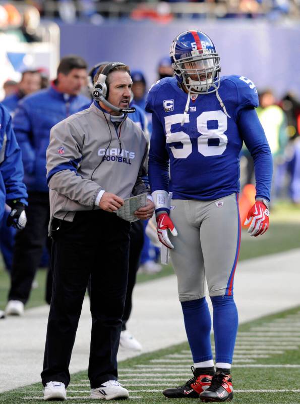 New York Giants defensive coordinator Steve Spagnuolo talks with linebacker Antonio Pierce (58) ...