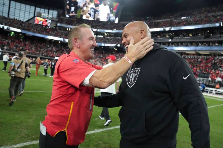 Kansas City Chiefs defensive coordinator Steve Spagnuolo, left, laughs with Las Vegas Raiders h ...