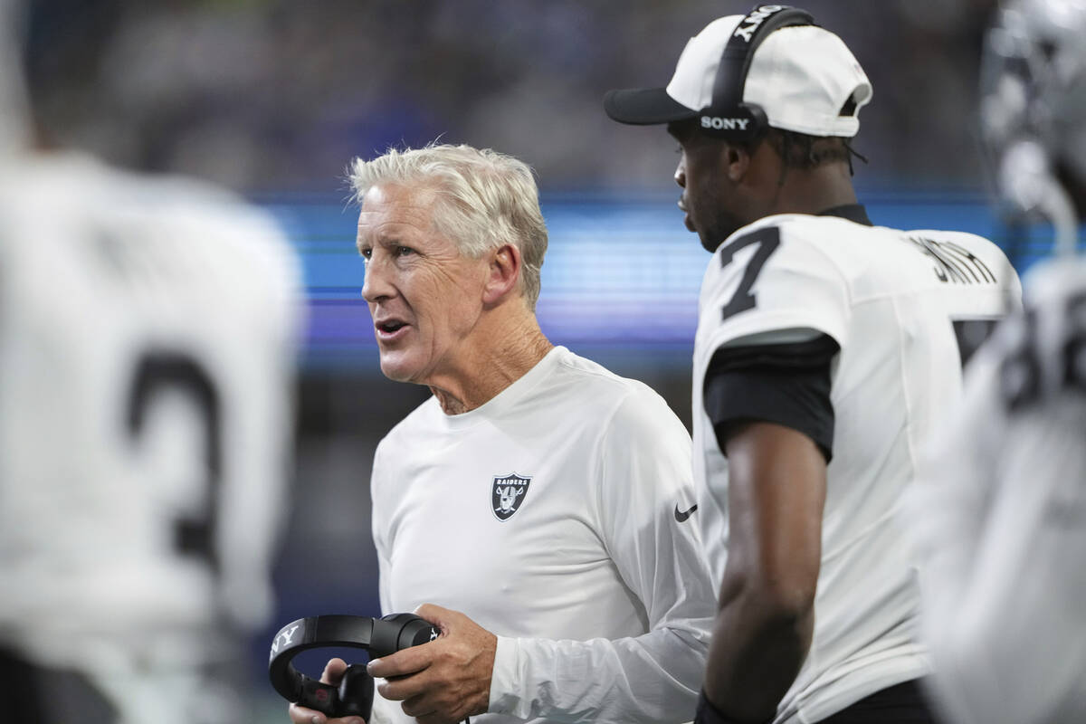 Las Vegas Raiders head coach Pete Carroll stands with quarterback Geno Smith (7) on the sidelin ...