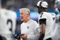 Las Vegas Raiders head coach Pete Carroll stands with quarterback Geno Smith (7) on the sidelin ...