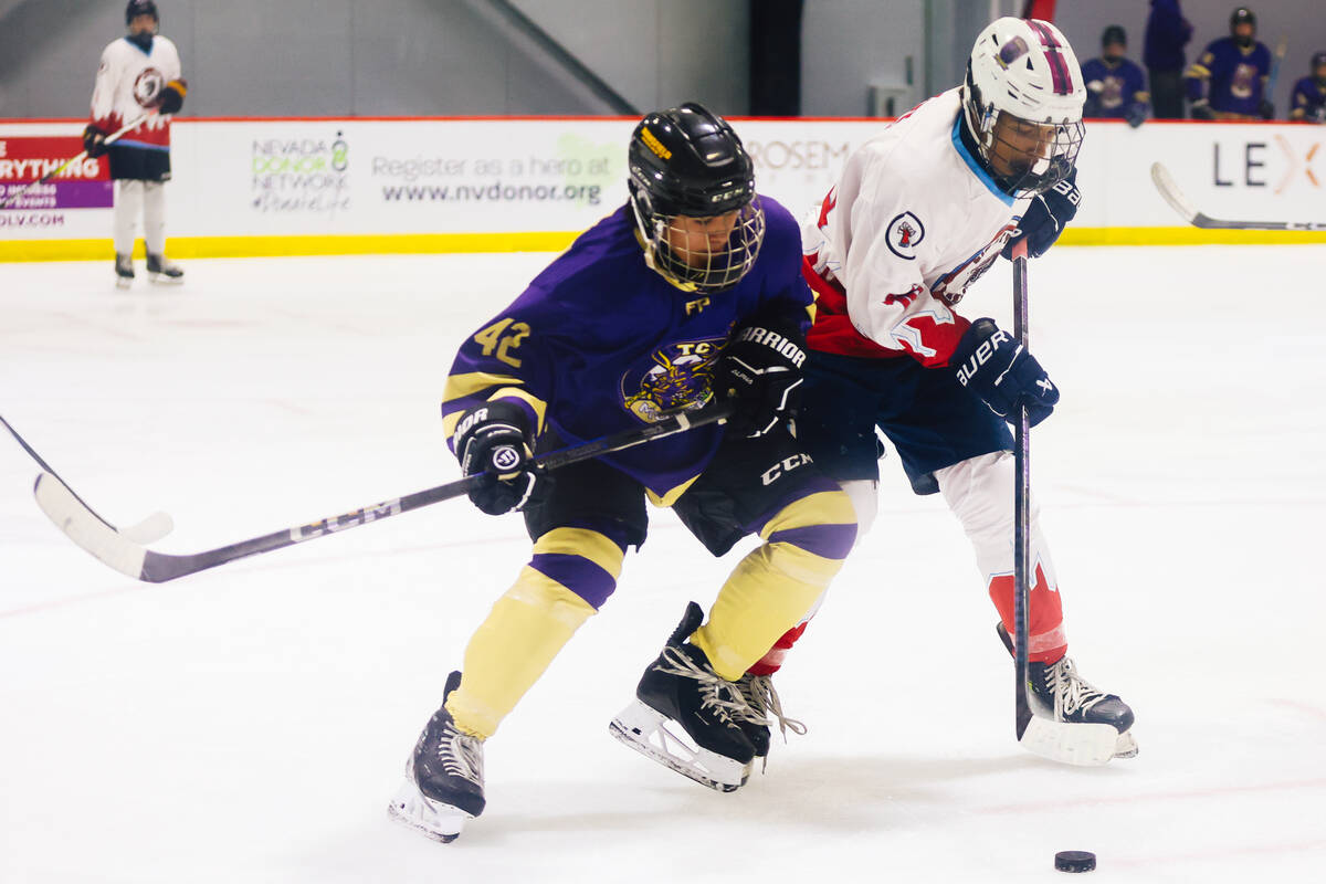 Players pursue the puck during a Golden Knights high school hockey league game at America First ...
