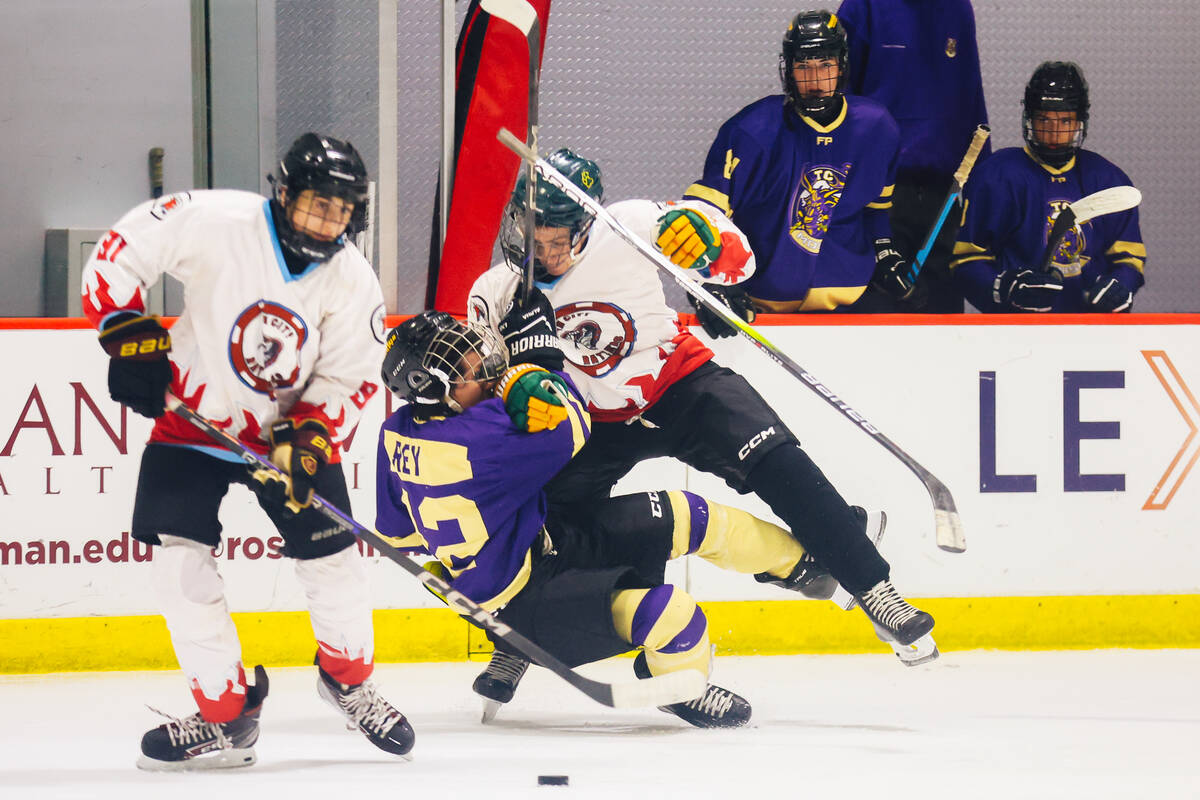 Players watch a fight ensue from the bench during a Golden Knights high school hockey league ga ...