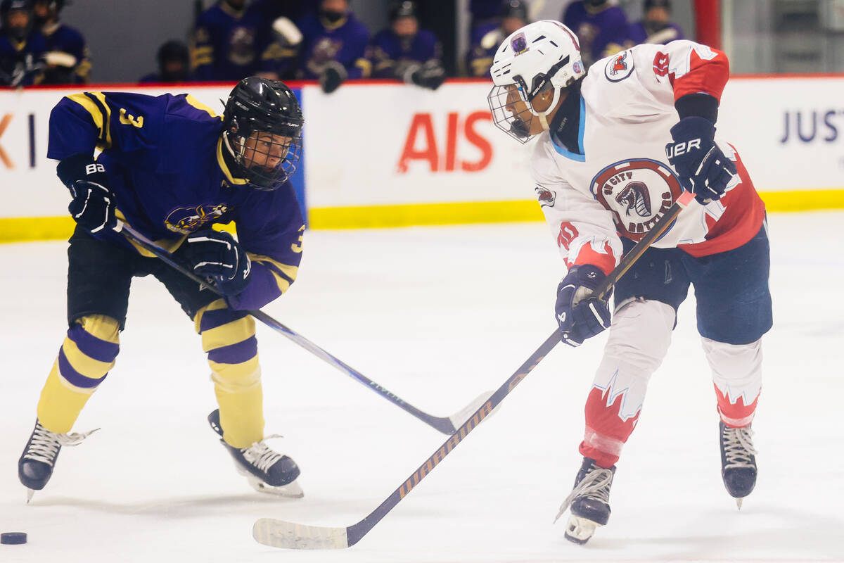 Players pursue the puck during a Golden Knights high school hockey league game at America First ...