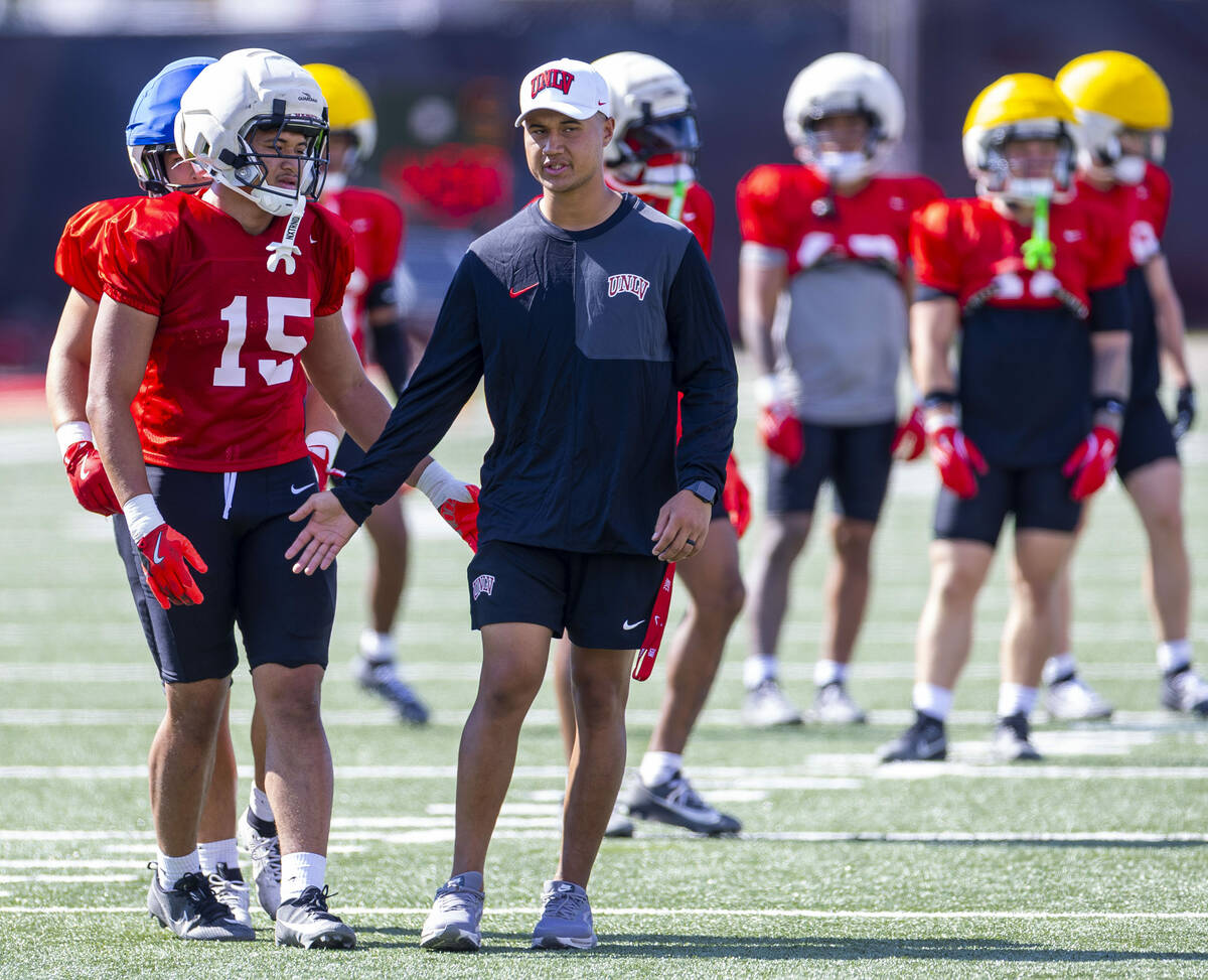 UNLV linebacker's coach Bam Amina works with linebacker Blesyng Alualu-Tuioemotu (15) during fo ...