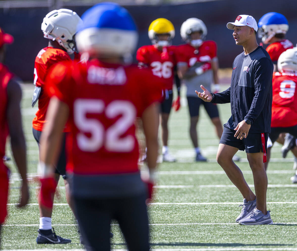 UNLV linebacker's coach Bam Amina speaks with a player during football practice at Fertitta Fie ...