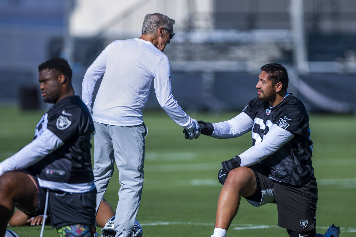 Raiders head coach Pete Carroll greets defensive tackle Treven Ma'ae (68) as he stretches with ...