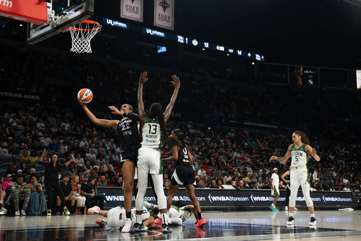 Las Vegas Aces center A'ja Wilson (22) barrels through defenders at a WNBA basketball game betw ...