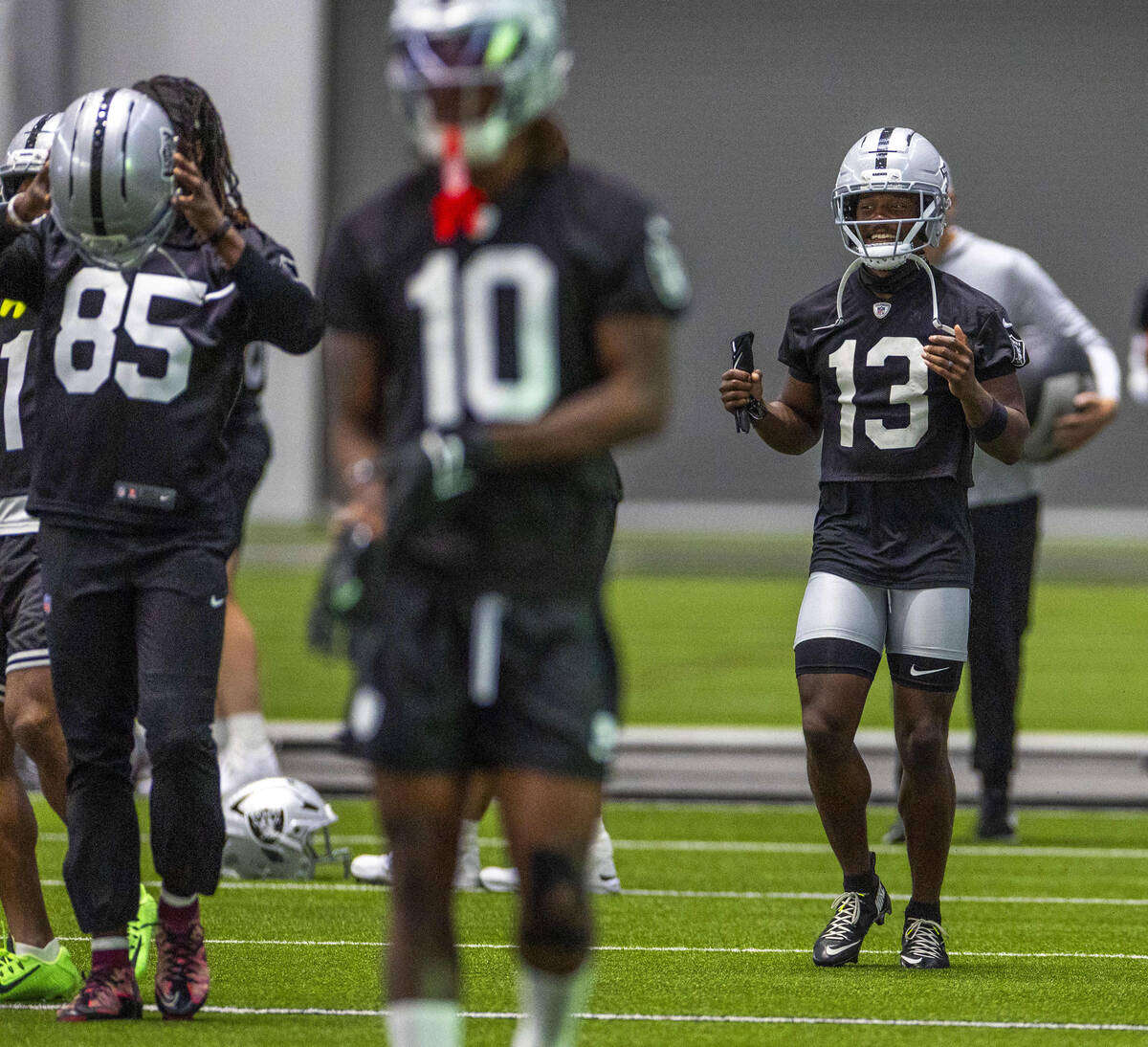 Raiders wide receiver Phillip Dorsett II (13) laughs at a teammate while warming up during trai ...