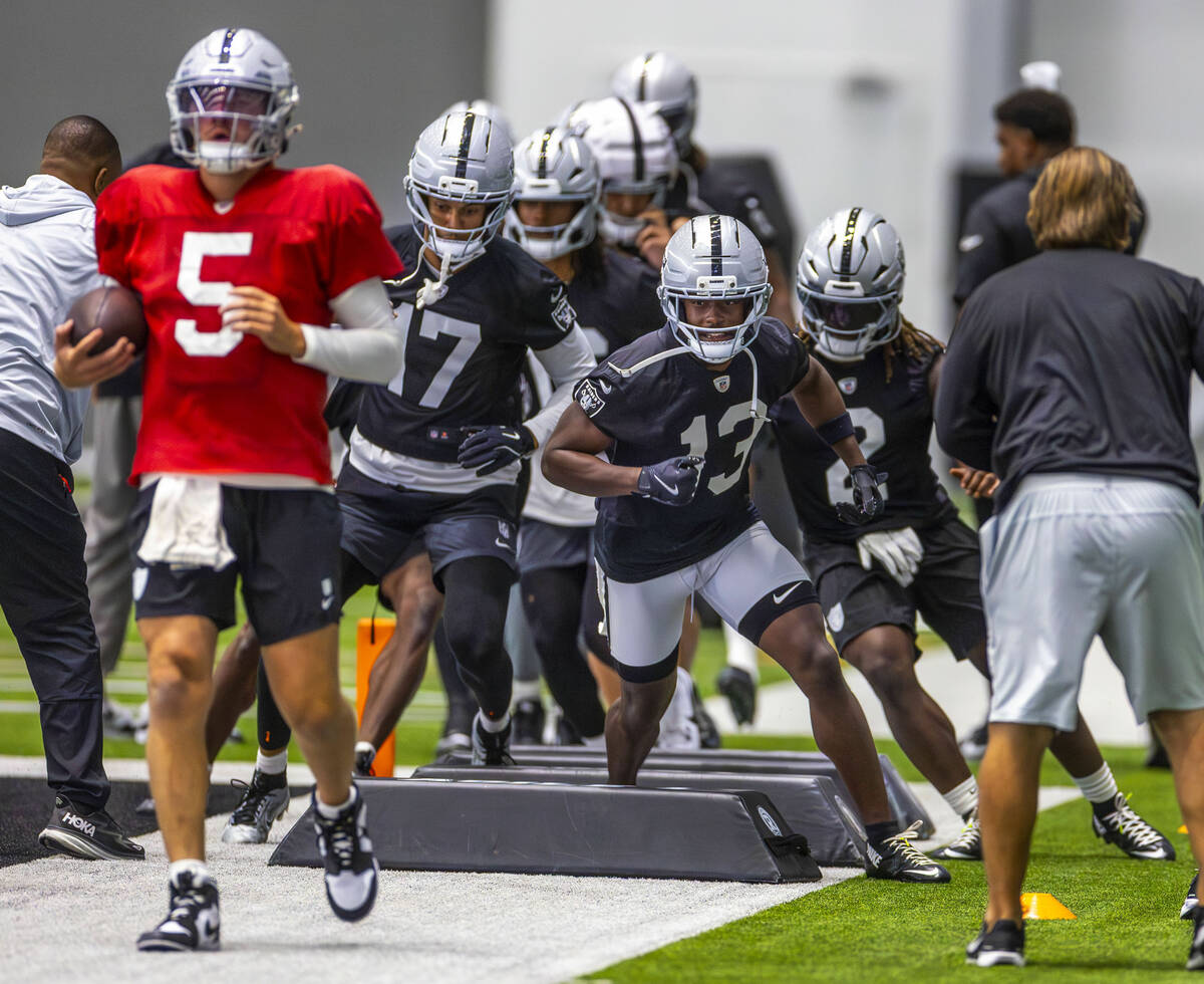Raiders wide receiver Phillip Dorsett II (13) follows quarterback Cam Miller (5) in a drill dur ...
