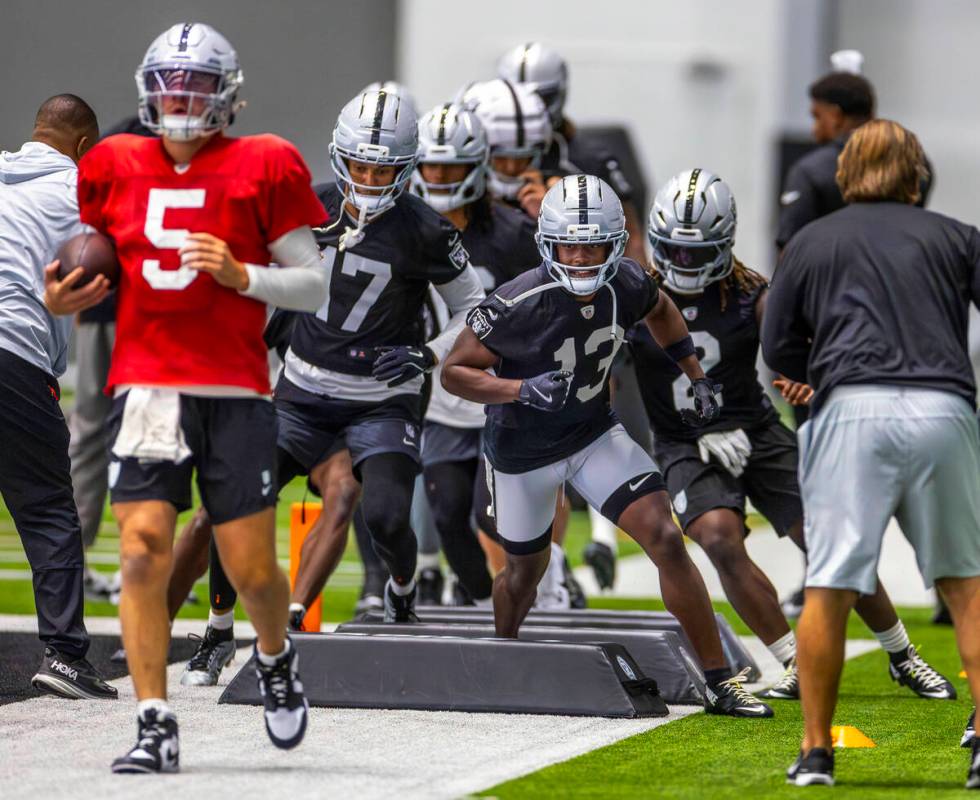 Raiders wide receiver Phillip Dorsett II (13) follows quarterback Cam Miller (5) in a drill dur ...