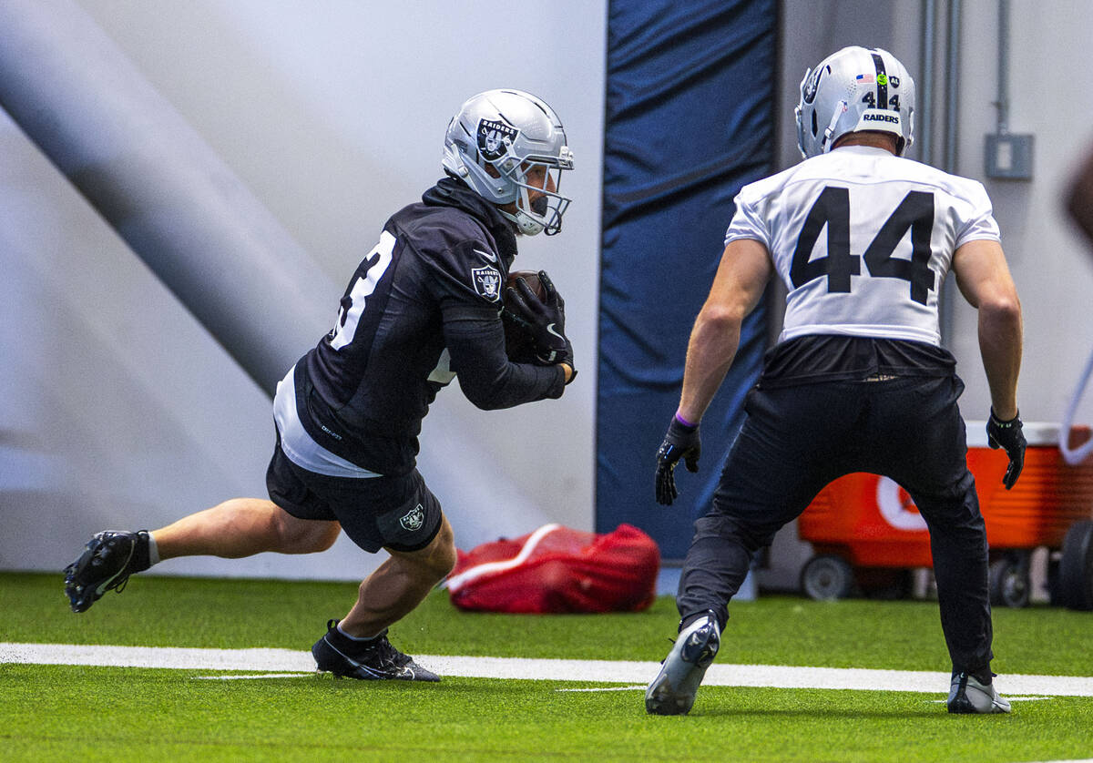Raiders running back Dylan Laube (23) runs down the sidelines with linebacker Tommy Eichenberg ...