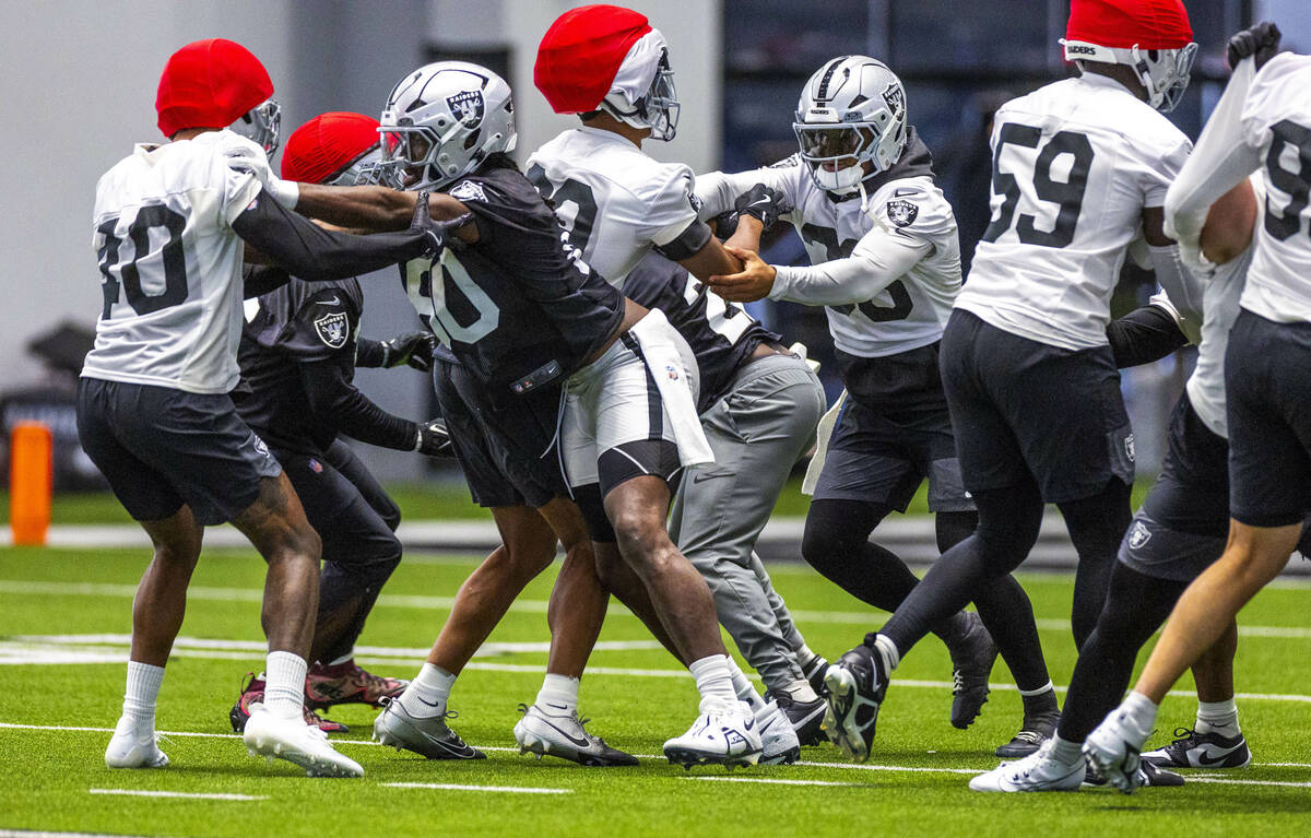 Raiders linebacker Jamal Adams (33) blocks out Raiders cornerback Darnay Holmes (30) during tra ...