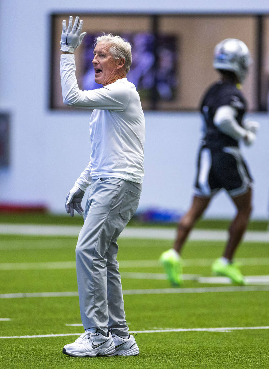 Raiders head coach Pete Carroll speaks to a player during training camp in the Intermountain He ...