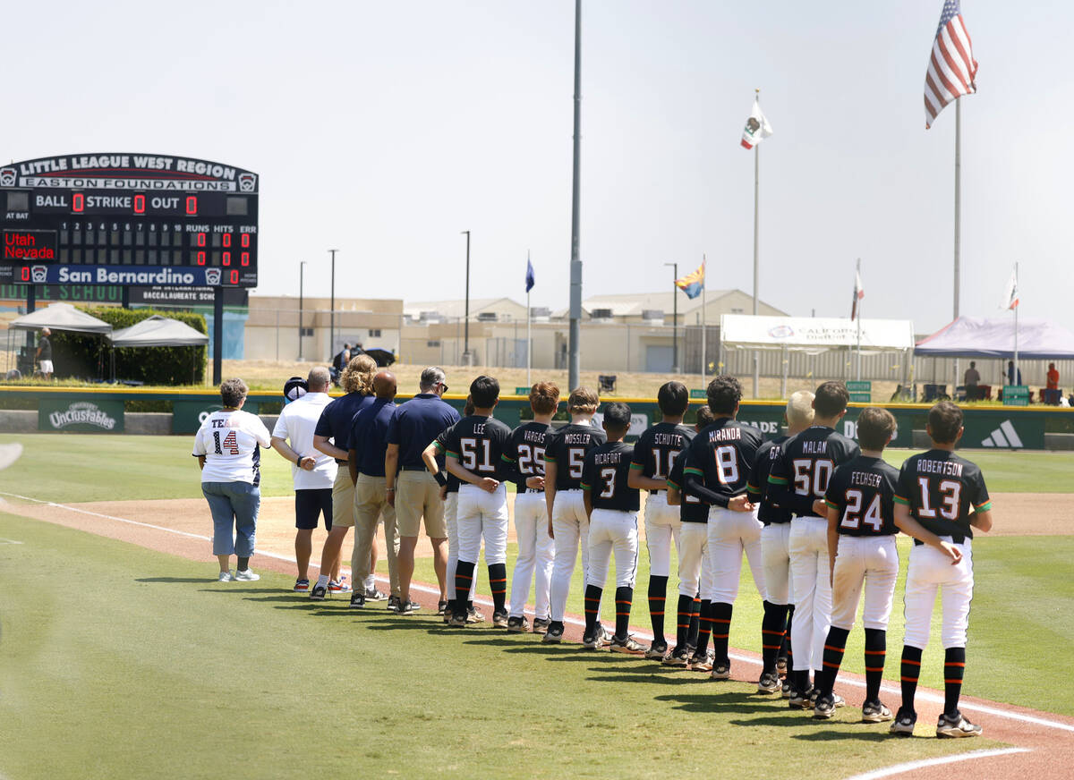 Nevada Little League baseball players and coaches line up during the National Anthem before the ...