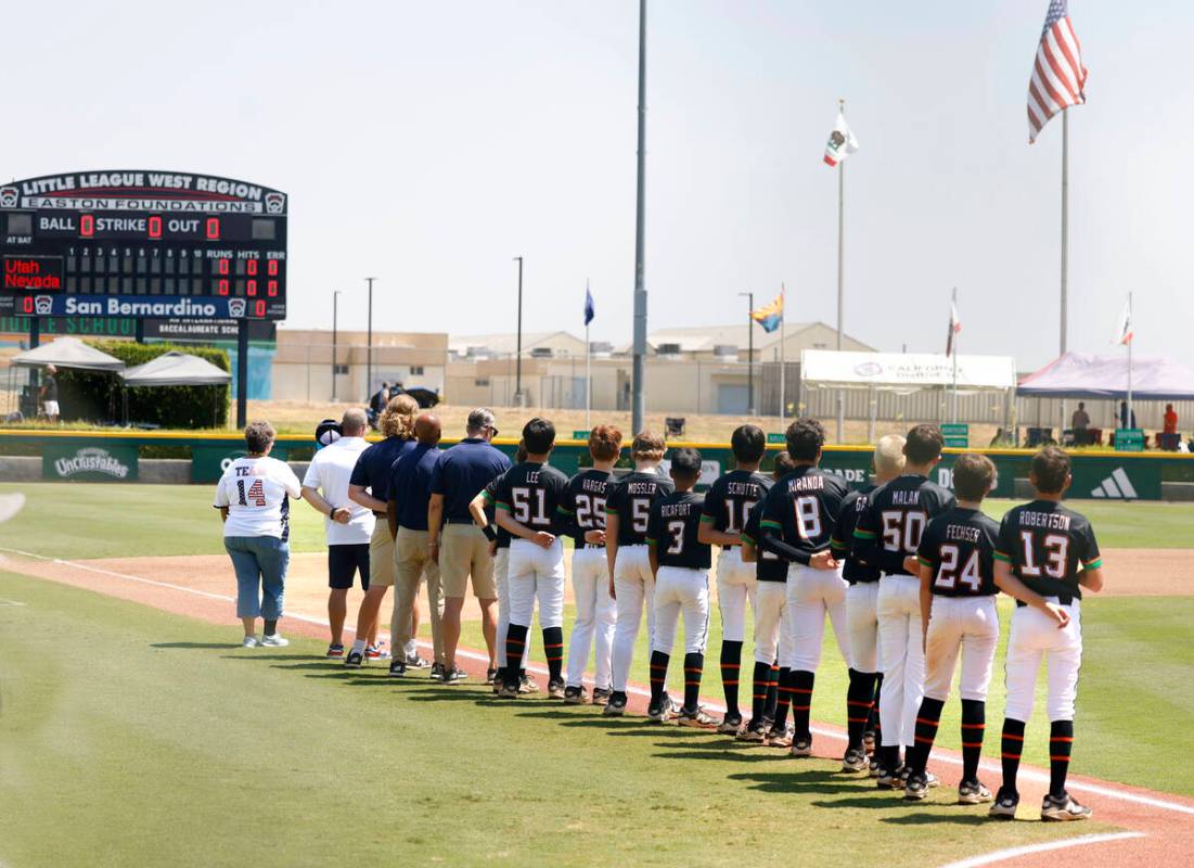 Nevada Little League baseball players and coaches line up during the National Anthem before the ...