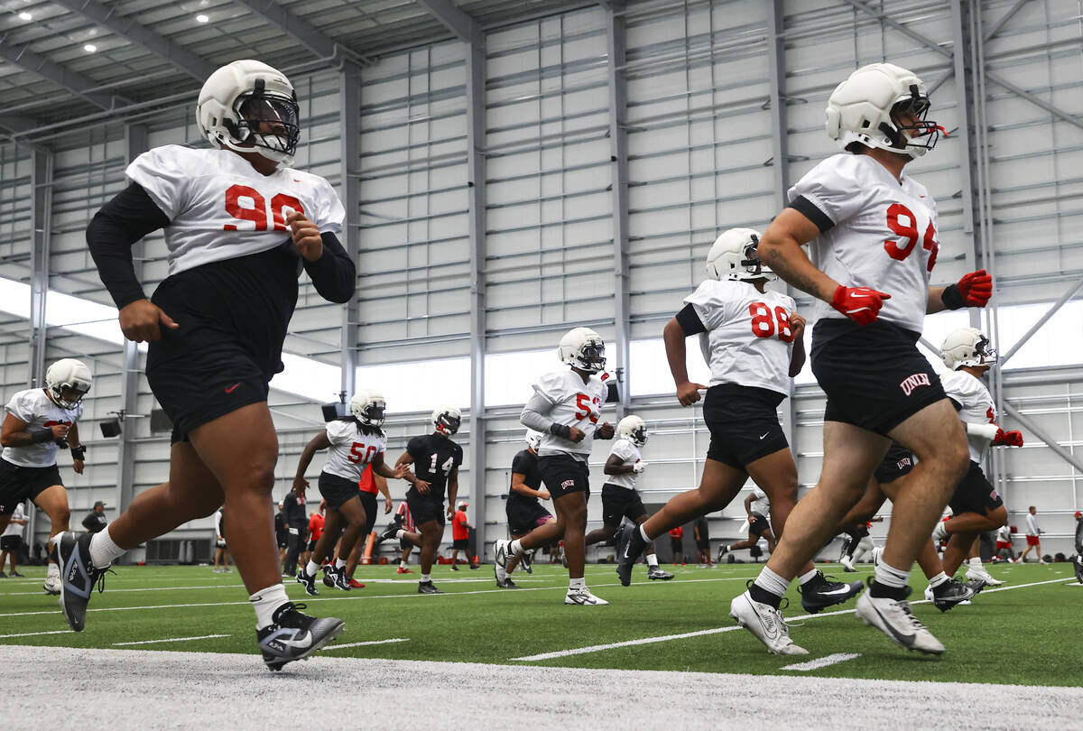 UNLV football players warm up during football practice at the Raiders headquarters and practice ...