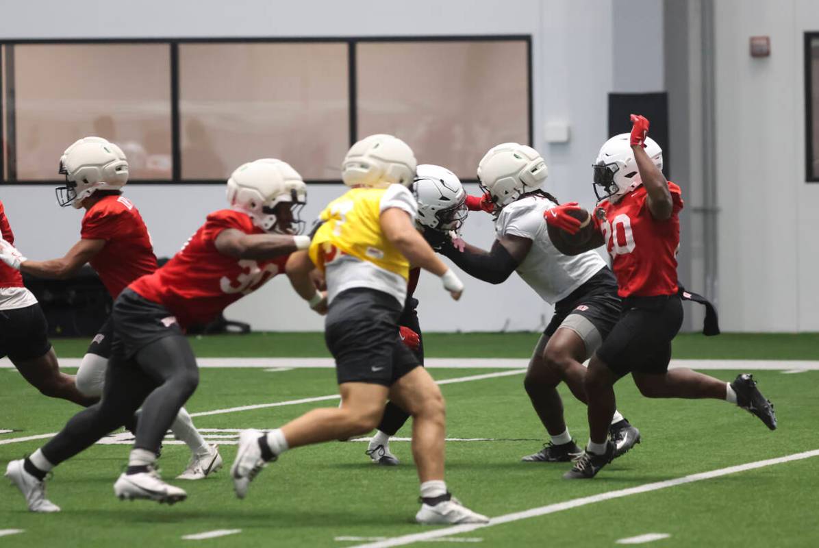 UNLV running back Jaylon Glover (20) carries the ball during football practice at the Raiders h ...