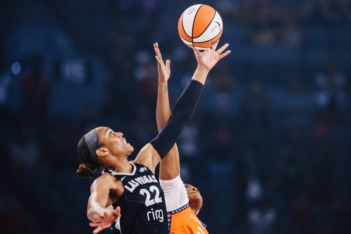 Aces center A'ja Wilson (22) reaches for the ball during tip off at a WNBA basketball game betw ...