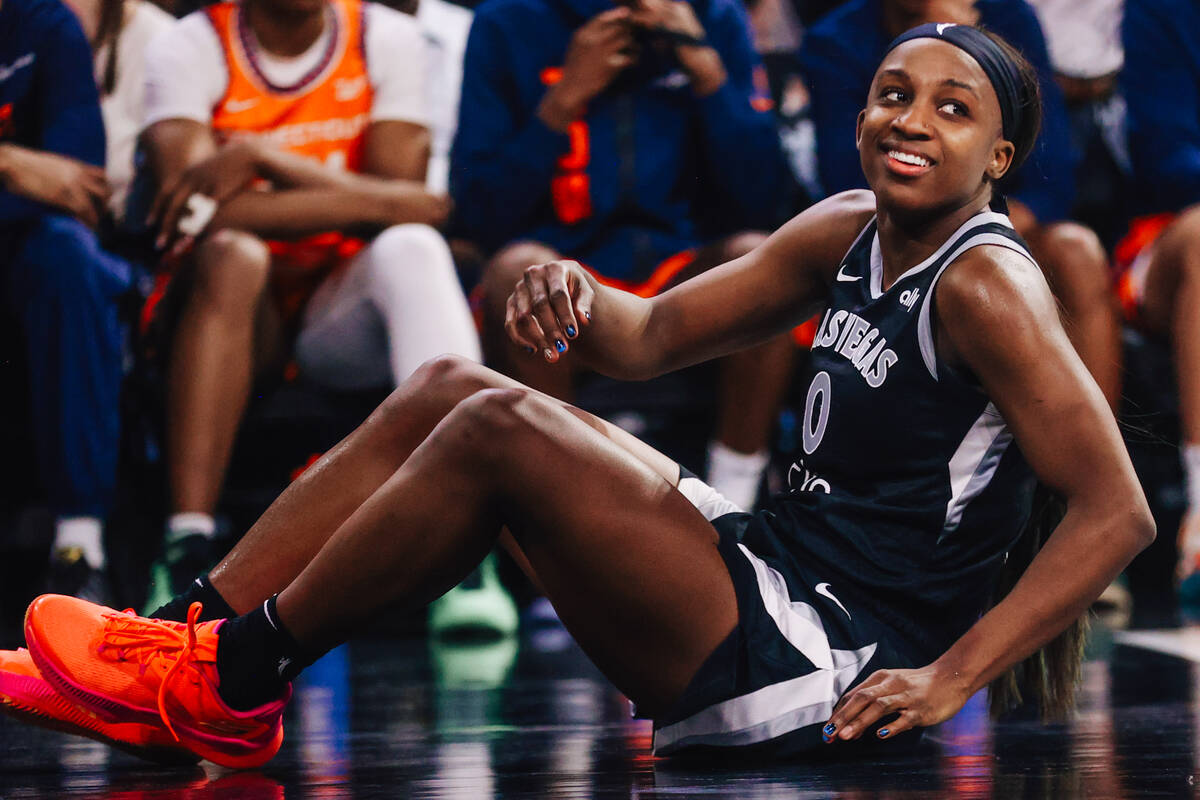 Aces guard Jackie Young smiles as she gets off the floor during a WNBA basketball game between ...