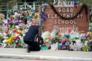 FILE - Reggie Daniels pays his respects a memorial at Robb Elementary School, Thursday, June 9, ...
