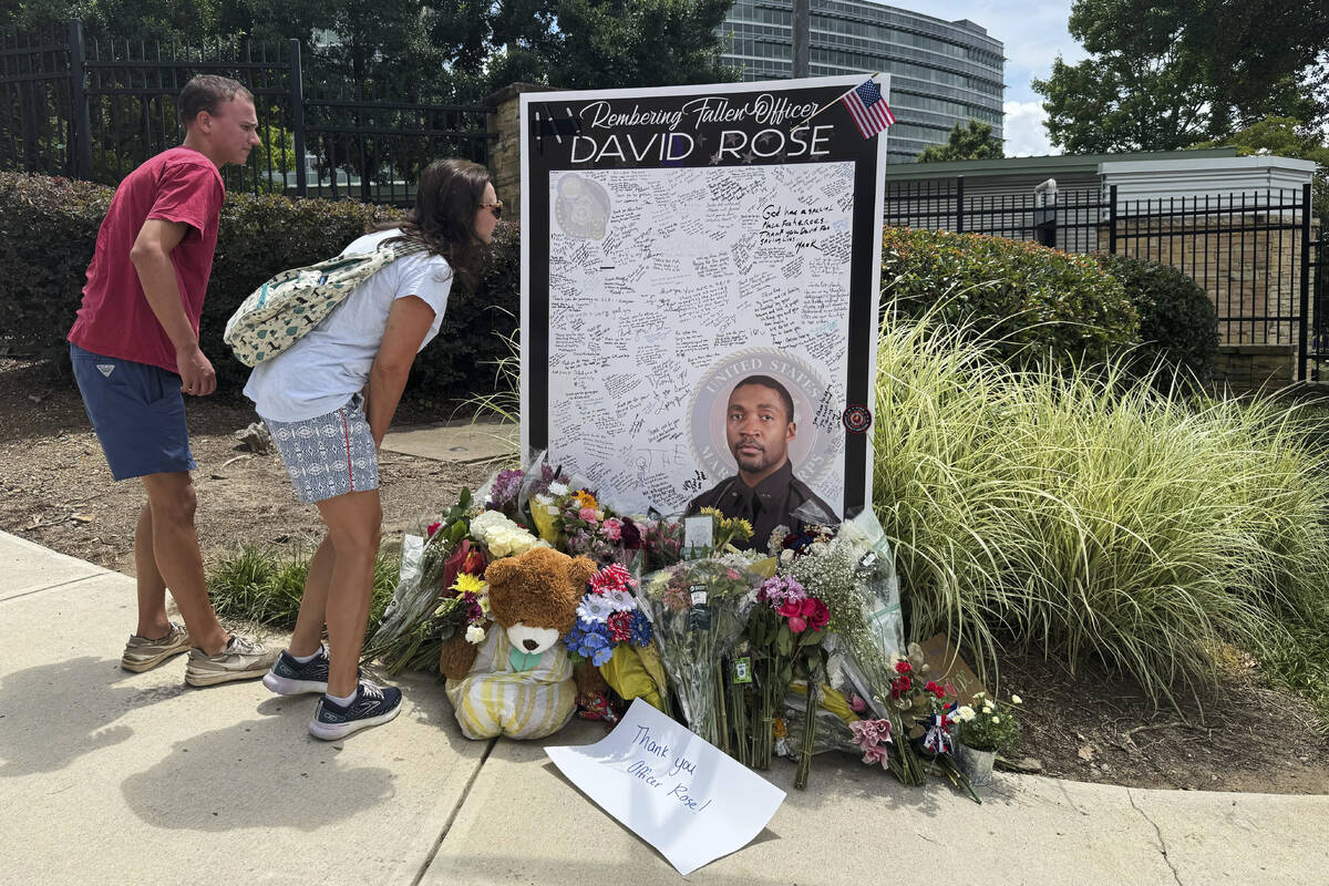 People leave flowers Monday, Aug. 11, 2025, at a makeshift memorial in honor of David Rose, the ...
