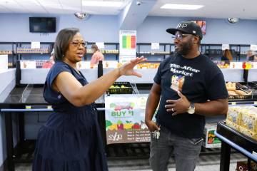 Dewayne McCoy, owner of The After Market, right, listens as North Las Vegas mayoral candidate D ...