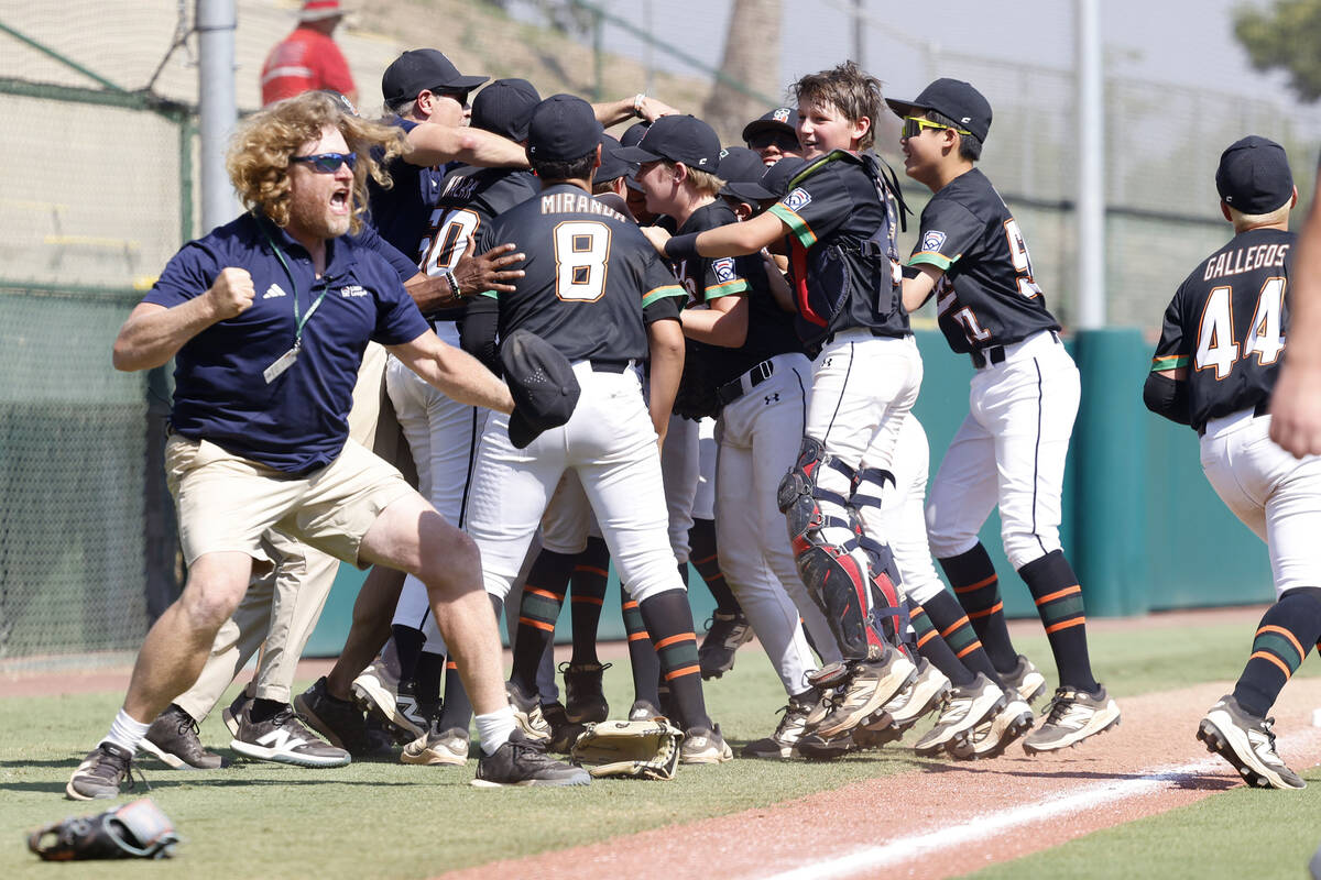 Nevada team head coach TJ Fechser, left, celebrates with his players after winning 6-3 against ...