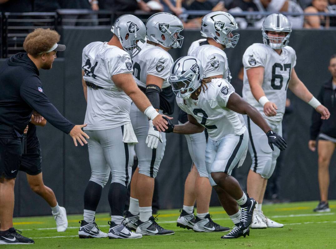 Raiders running back Ashton Jeanty (2) greets teammates during the first half of a Raiders trai ...